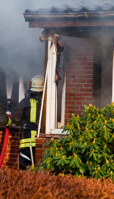 fireman at house on fire causing damage